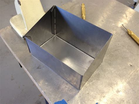 a metal worker is making a box|sheet metal box layout.